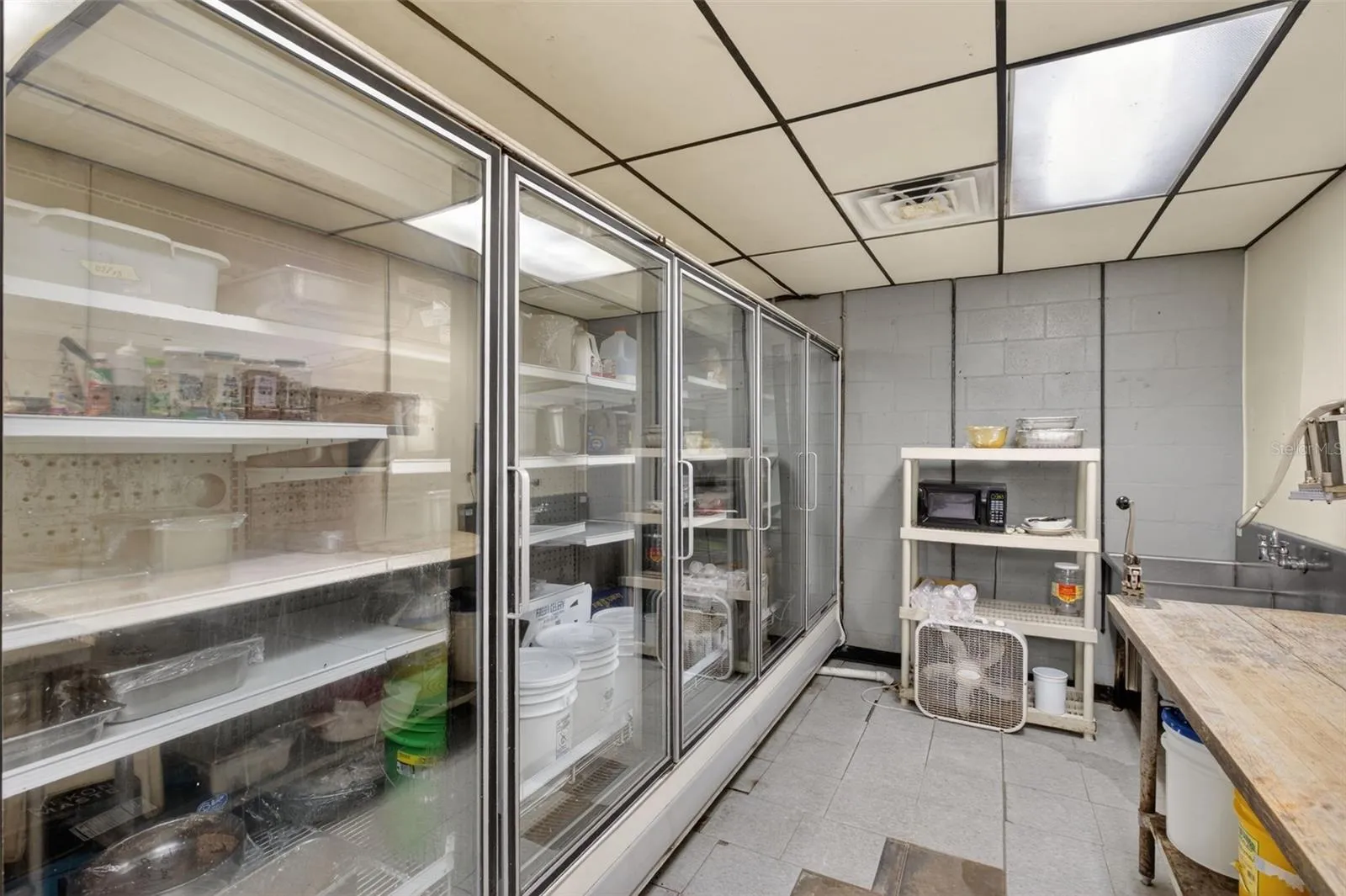 Fully equipped commercial kitchen infrastructure including hood system, fryers, ranges, griddles, and prep stations.