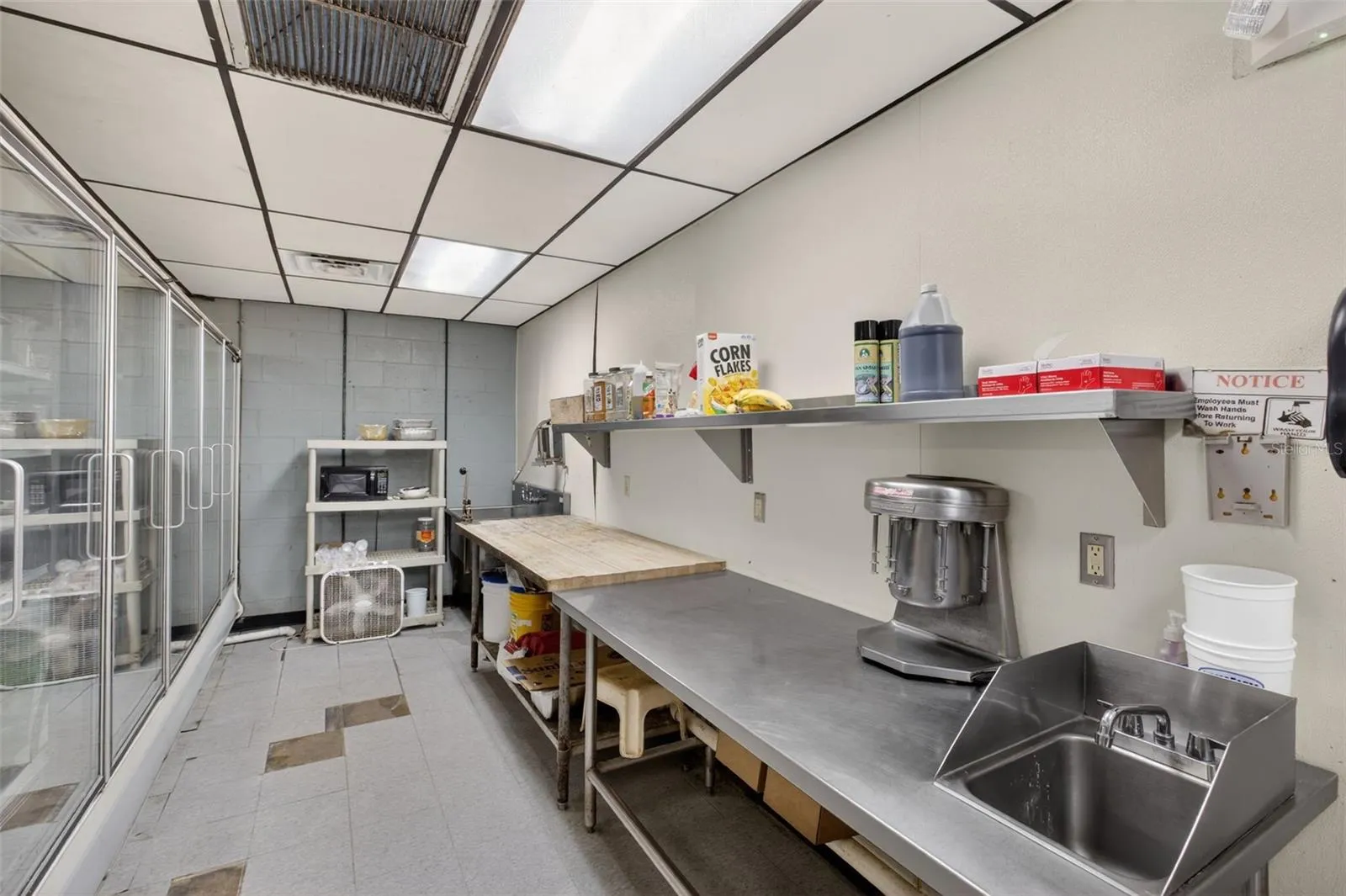 Fully equipped commercial kitchen infrastructure including hood system, fryers, ranges, griddles, and prep stations.