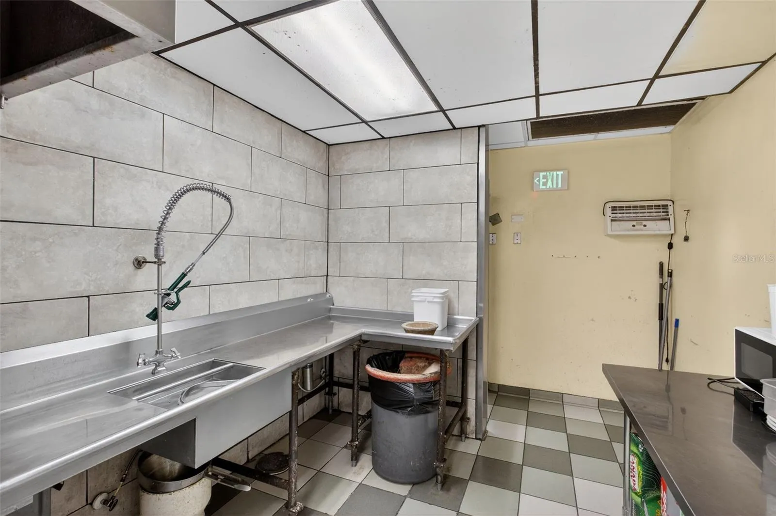 Fully equipped commercial kitchen infrastructure including hood system, fryers, ranges, griddles, and prep stations.