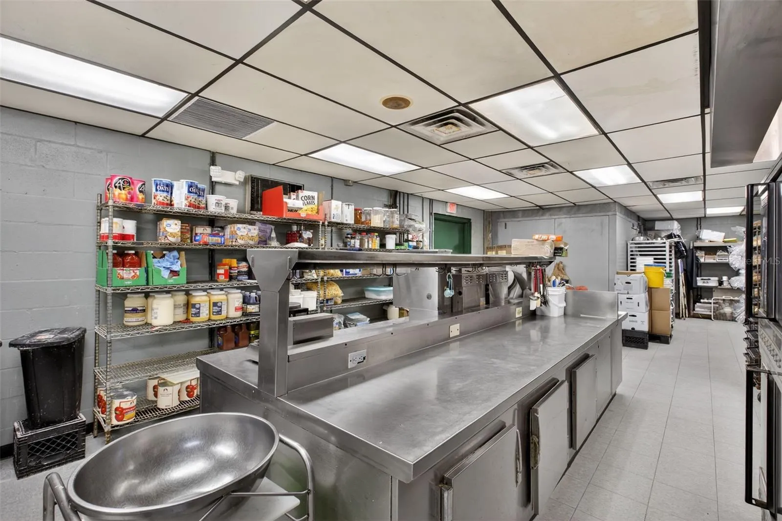 Fully equipped commercial kitchen infrastructure including hood system, fryers, ranges, griddles, and prep stations.