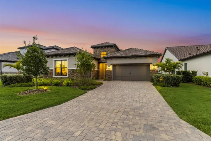 Evening lighting highlights the home's architectural details and inviting curb appeal, creating a warm and welcoming first impression.