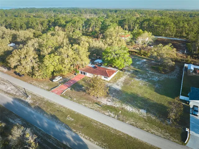 FRONT DRONE OF HALF ACRE PARCEL WITH MATURE TREES
