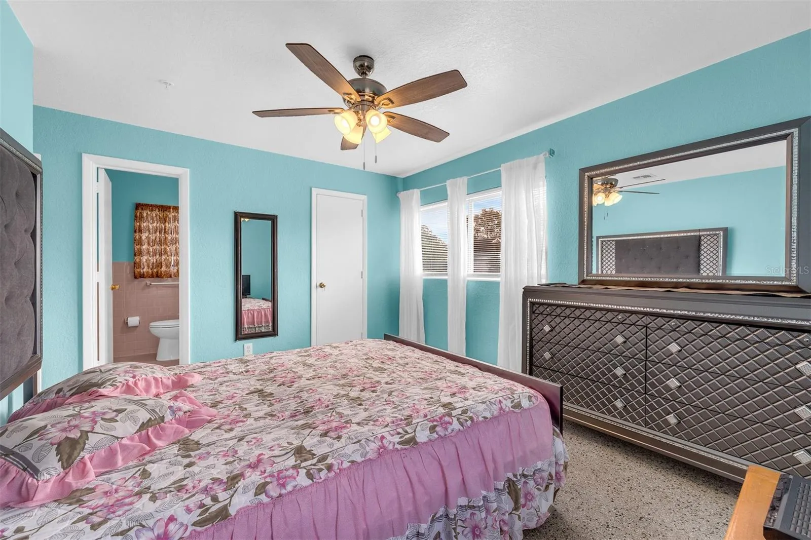 Bathroom with retro tile accents, vanity with storage, overhead lighting, and a window for ventilation. Includes built-in tile accessories and a combination of vintage and updated finishes.
