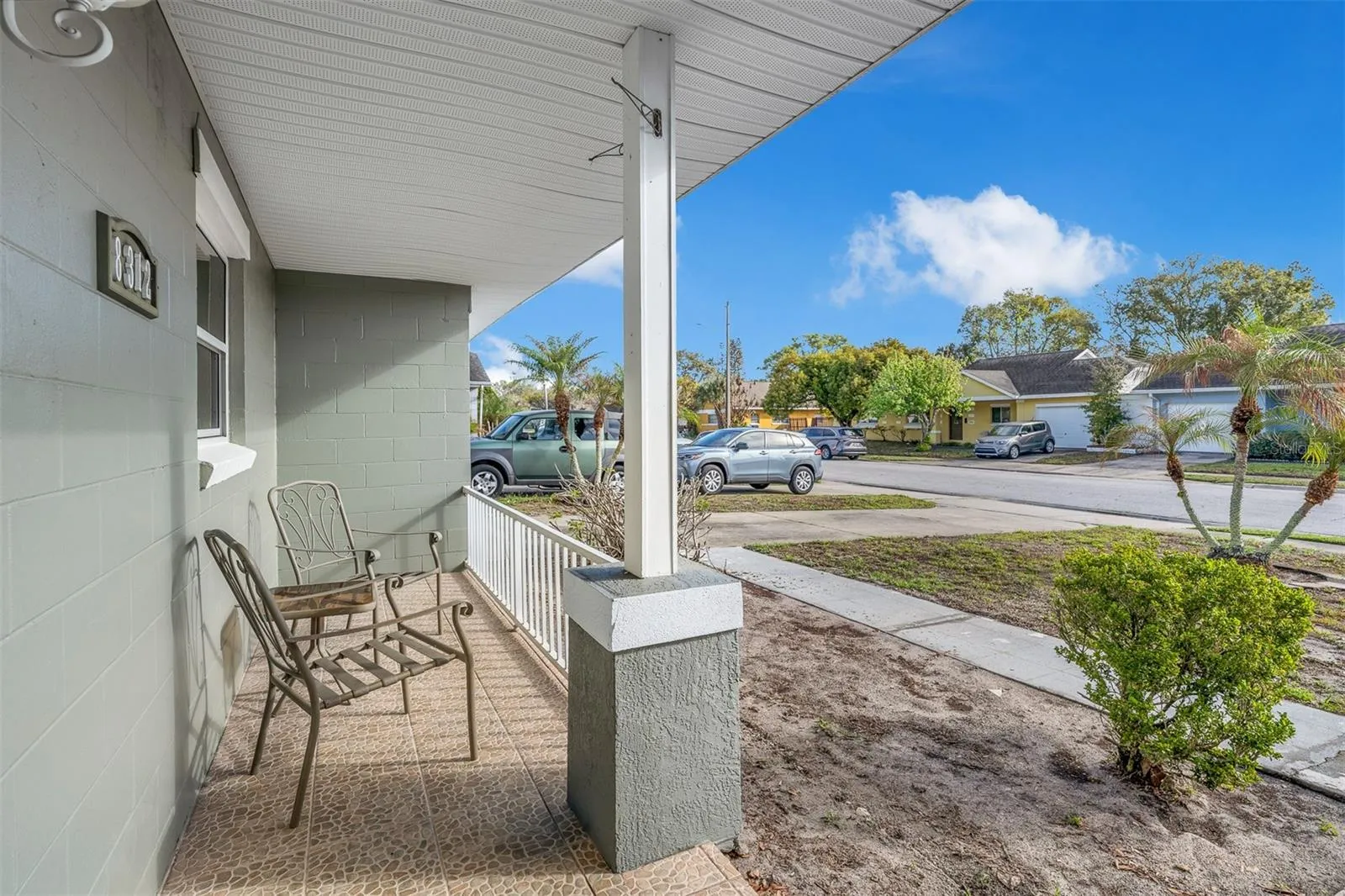 View from the covered porch overlooking the front yard and neighborhood. Ample space for outdoor seating and relaxation.