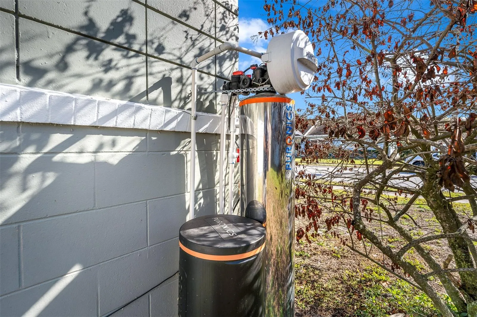 Exterior water treatment system with dual filtration units and PVC connections.
