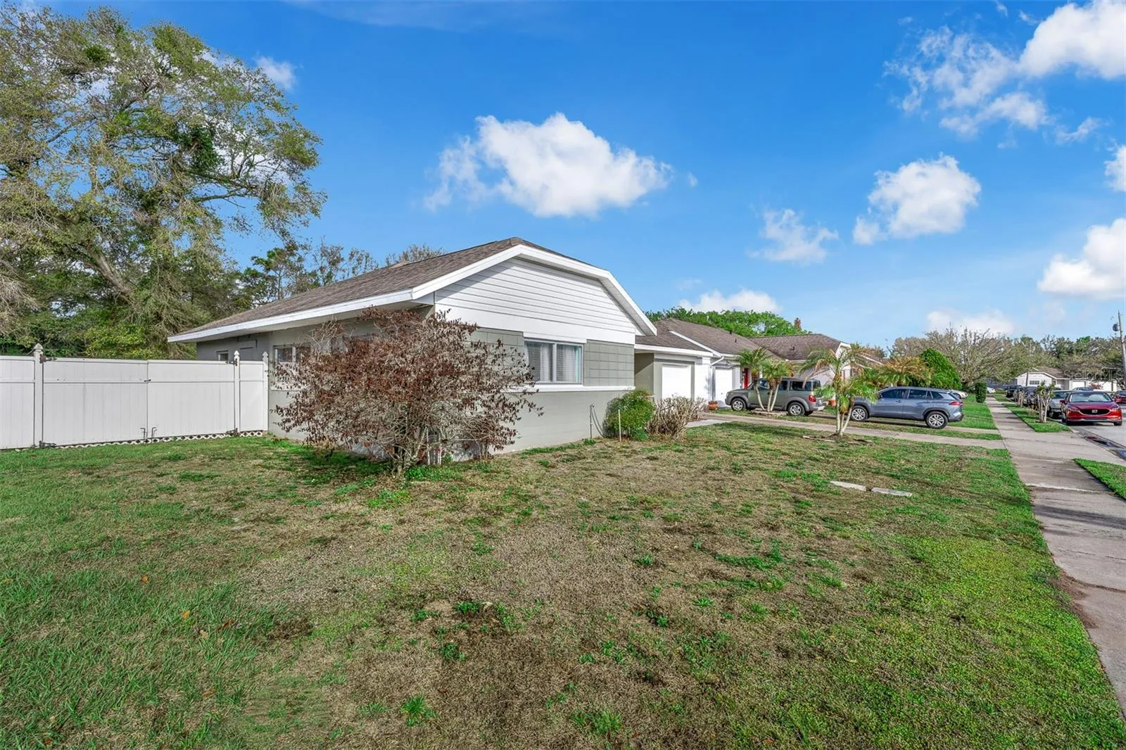 Quiet residential street with well-kept neighboring homes and multiple parking options. Level lot with a fenced side yard visible from the front.