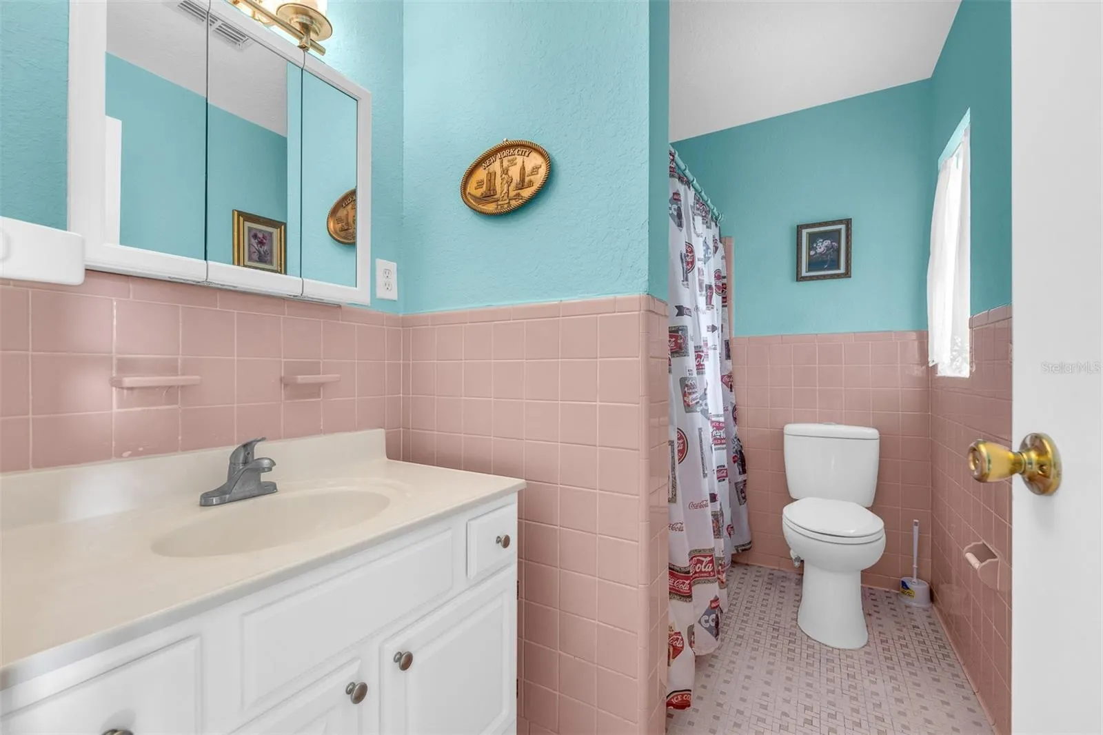 Bathroom with mid-century tile, vanity with storage, and mirrored medicine cabinet.