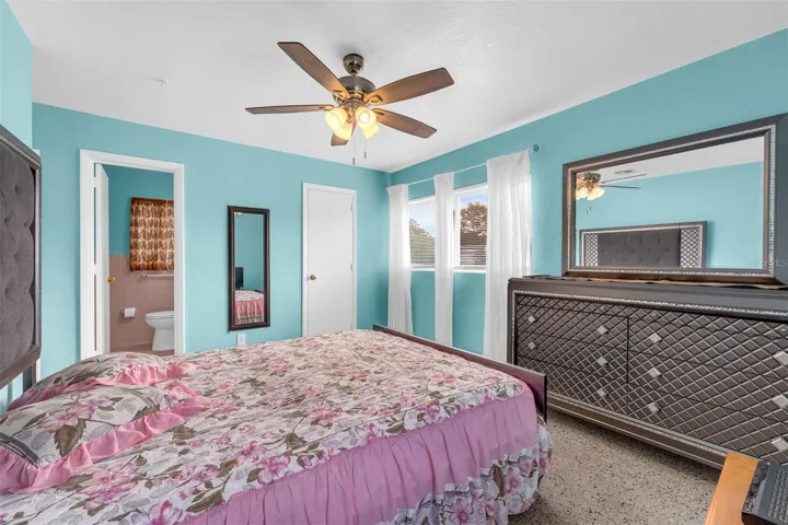 Bathroom with retro tile accents, vanity with storage, overhead lighting, and a window for ventilation. Includes built-in tile accessories and a combination of vintage and updated finishes.