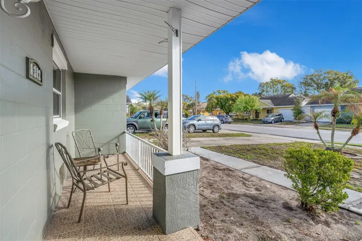 View from the covered porch overlooking the front yard and neighborhood. Ample space for outdoor seating and relaxation.