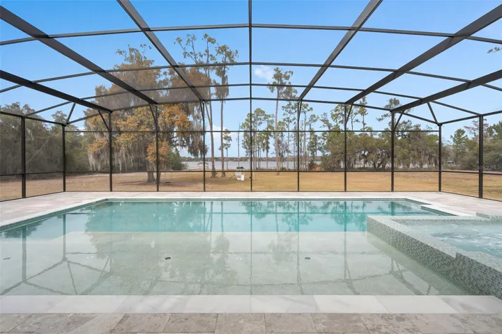 A newly constructed oversized saltwater pool featuring expansive sun shelf , resort style spa, and endless lakefront views.