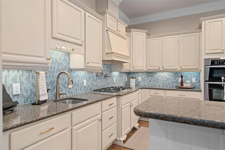 Thoughtfully designed custom kitchen featuring a hidden pantry along with built-in cutting board, trash disposal, and sponge storage for a clean, seamless look.