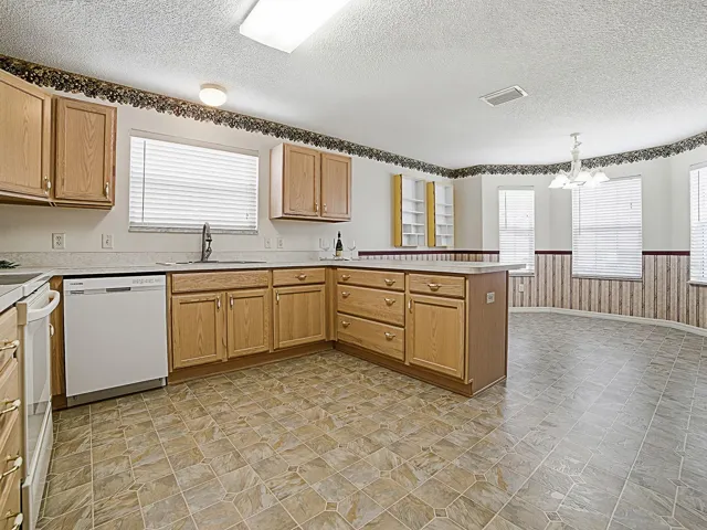 The kitchen features a breakfast bar, solid wood cabinetry with convenient pull-out shelves, and a large pantry to meet all your storage needs.