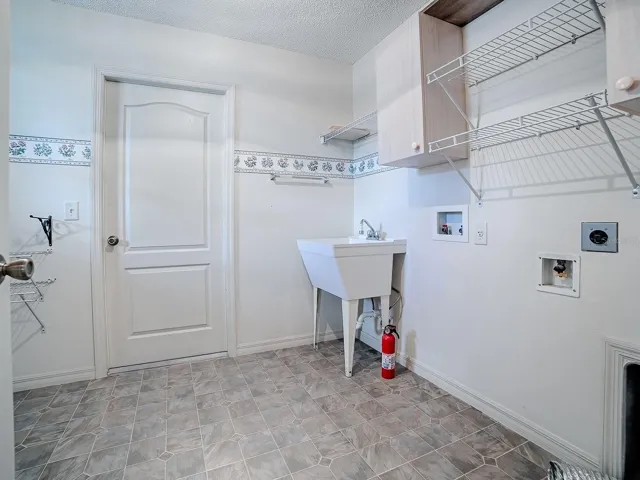 Inside laundry with set sink and shelving for extra storage.