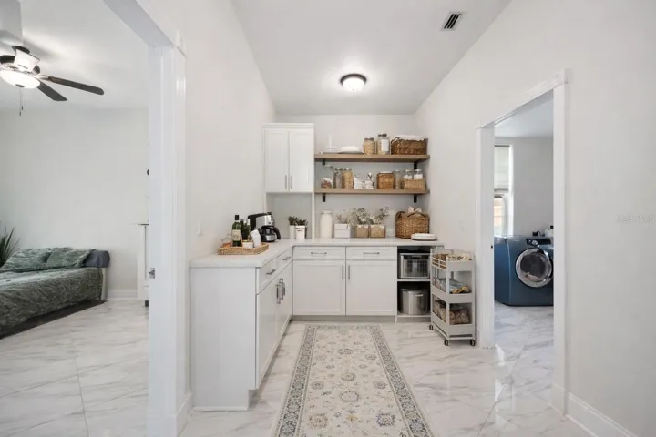 Virtual staging added to demonstrate possible furniture placement- potential butlers pantry. Currently no cabinets in the area.