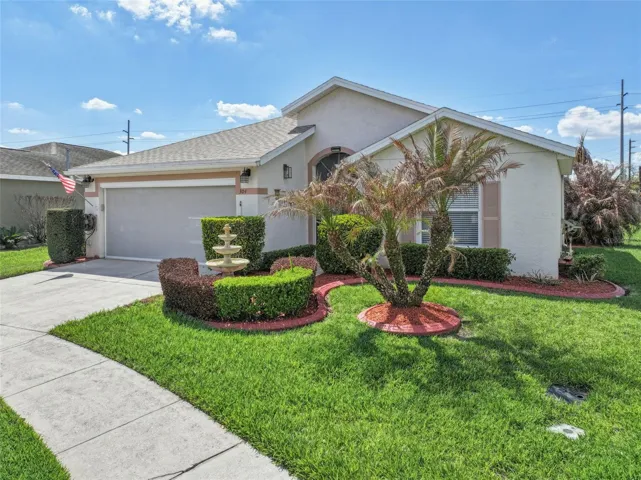 Charming Curb Appeal featuring a Water Fountain and Decorative Stone Landscape Curbing