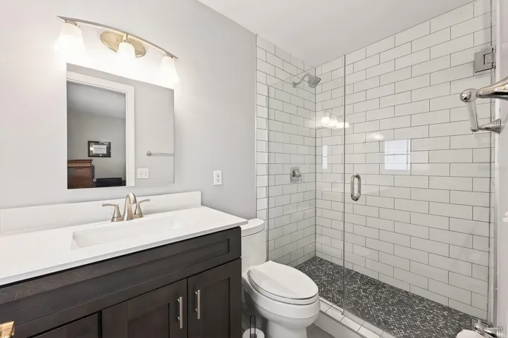 The updated en suite bath features a modern vanity and a beautifully tiled step-in shower with glass enclosure.