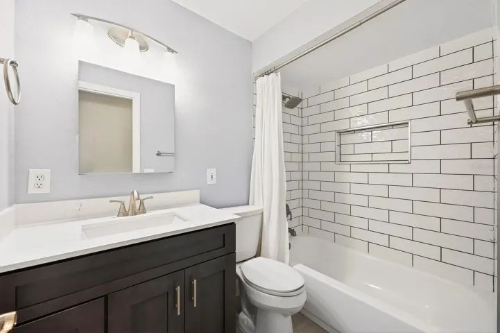 Two additional bedrooms, each with ceiling fans and luxury carpeting, are conveniently located near a second updated full bath.