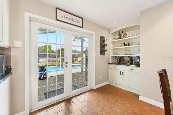 The Dining space is enhanced with built-in shelving and a custom bar area, while French doors open to the backyard retreat.