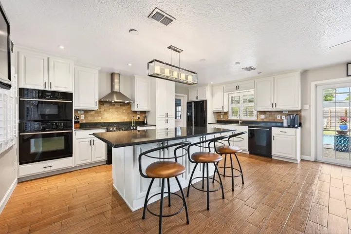 The heart of the home is the stunningly renovated Kitchen and Dining area, where wood-look tile flooring sets the stage for a bright and modern design.
