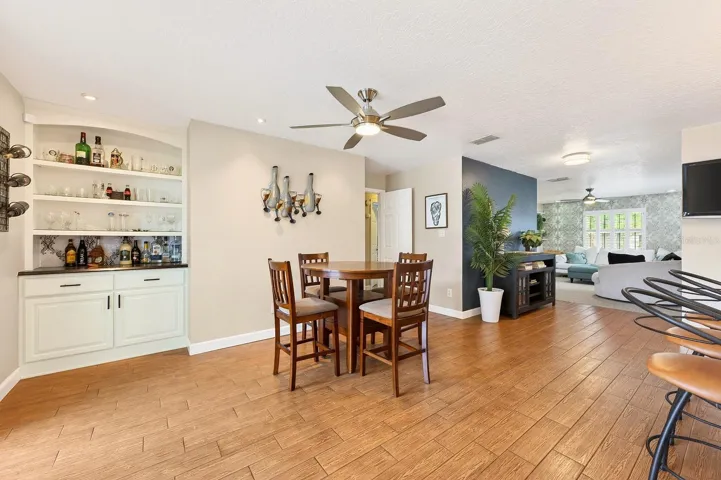 The Dining space is enhanced with built-in shelving and a custom bar area, while French doors open to the backyard retreat.