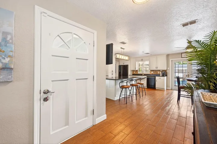 The heart of the home is the stunningly renovated Kitchen and Dining area, where wood-look tile flooring sets the stage for a bright and modern design.