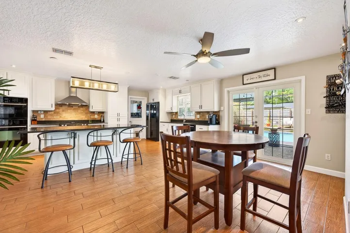 The Dining space is enhanced with built-in shelving and a custom bar area, while French doors open to the backyard retreat.