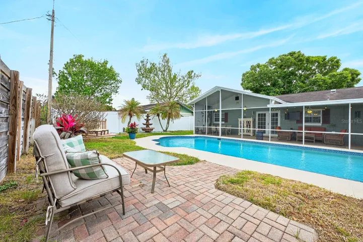 Additional outdoor spaces include a charming wood deck and a separate seating area, ideal for entertaining or relaxing in the Florida sunshine.