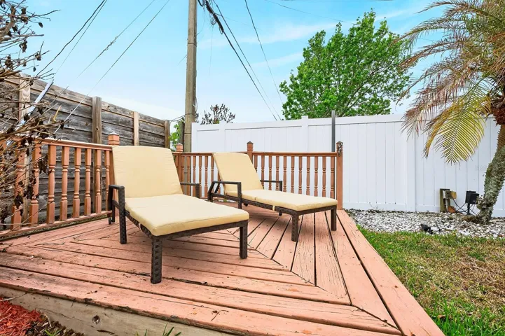 Additional outdoor spaces include a charming wood deck and a separate seating area, ideal for entertaining or relaxing in the Florida sunshine.