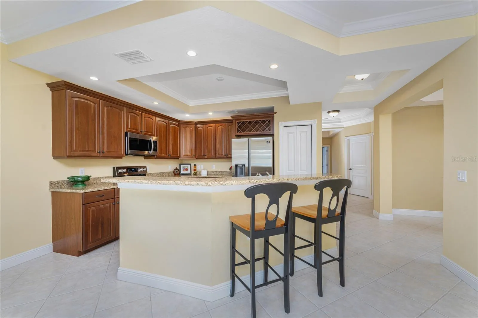 Custom cabinetry, granite countertops, built-in wine rack, and a coffered tray ceiling — luxury and function, perfectly paired.