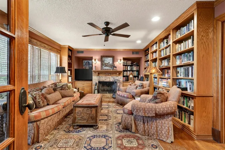 “A richly appointed private library offers warmth, character, and timeless sophistication, featuring floor-to-ceiling built-ins, handsome wood detailing, and a beautiful fireplace that creates the perfect setting for reading, working, or quiet conversation.”