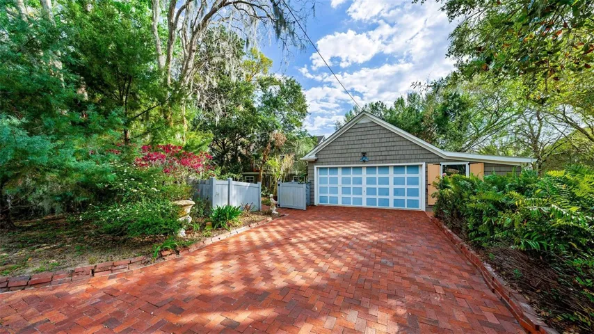 Beautiful red brick driveway into 2 car garage.