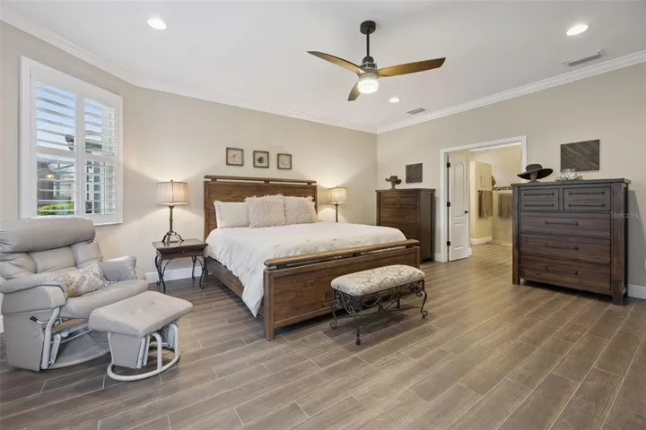 Large primary bedroom with crown molding.