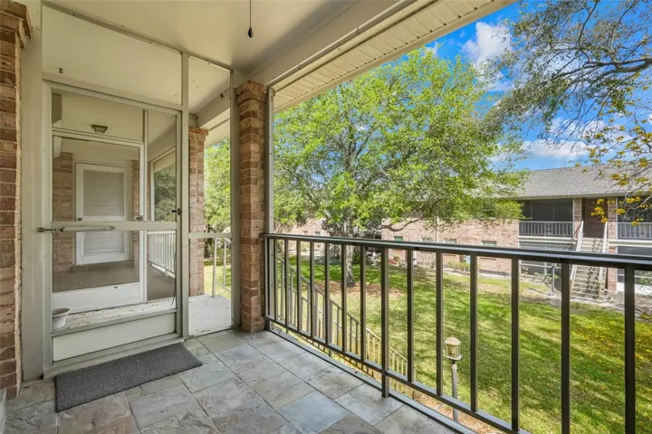 Balcony patio with stairs down to back lawn area
