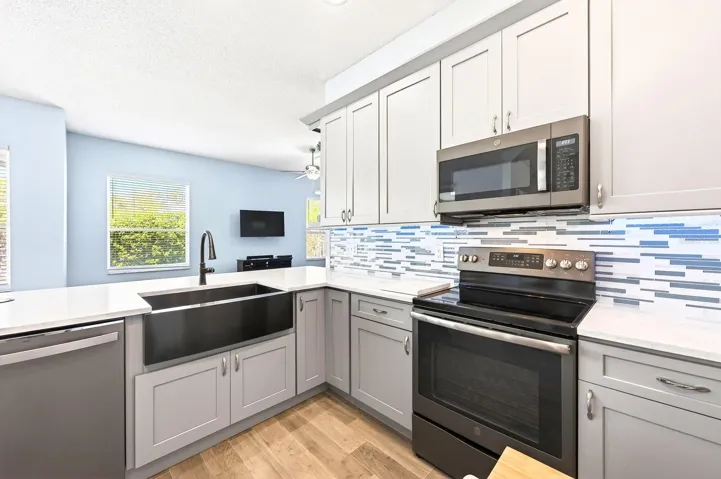 The FULLY REMODELED KITCHEN (2022) is a standout feature, showcasing QUARTZ COUNTERTOPS, a stylish backsplash, NEW STAINLESS STEEL APPLIANCES (2020), a breakfast bar, closet pantry, and a bright breakfast nook.