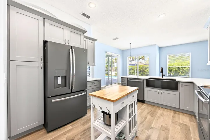 The FULLY REMODELED KITCHEN (2022) is a standout feature, showcasing QUARTZ COUNTERTOPS, a stylish backsplash, NEW STAINLESS STEEL APPLIANCES (2020), a breakfast bar, closet pantry, and a bright breakfast nook.