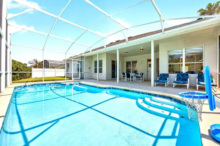 Step outside to your private retreat, where a covered patio and screened lanai enclose the SPARKLING IN-GROUND POOL AND SPA, offering the perfect setting for relaxing or entertaining year-round.