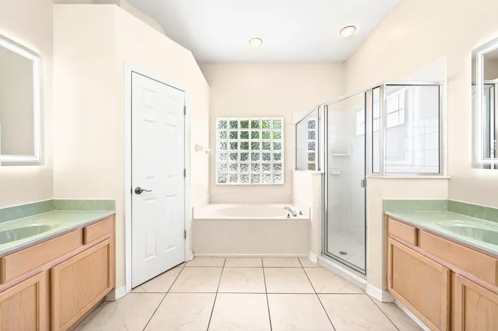 Unwind after a long day in the LUXURIOUS EN SUITE BATH offering dual vanities, garden tub, step-in shower, and a private water closet.