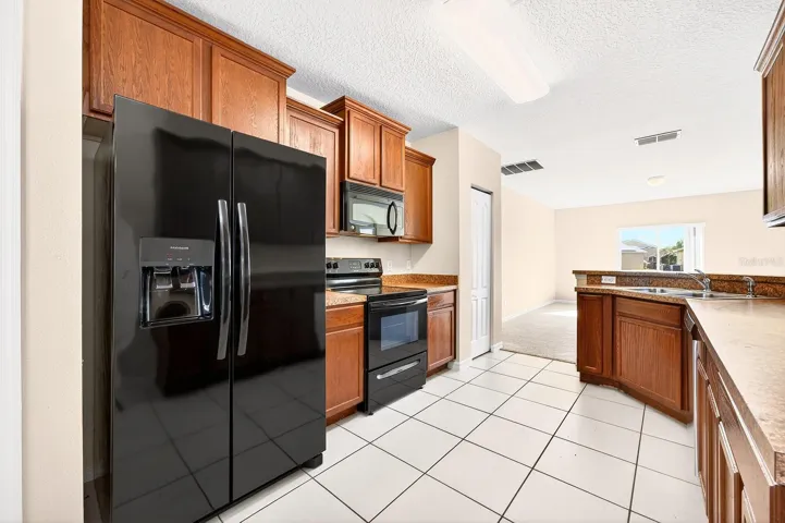 The EAT-IN KITCHEN is well equipped with ample cabinet and counter space, quality appliances, pantry storage, and a dining nook, and it opens directly to the spacious living room for easy entertaining and daily living.