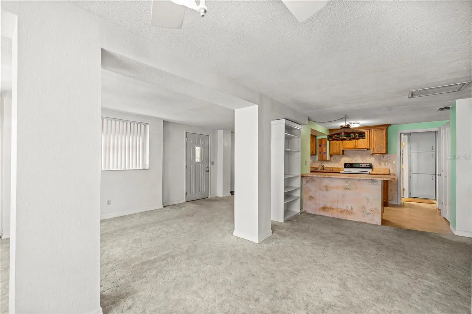 view to kitchen and entry from living room virtual staged