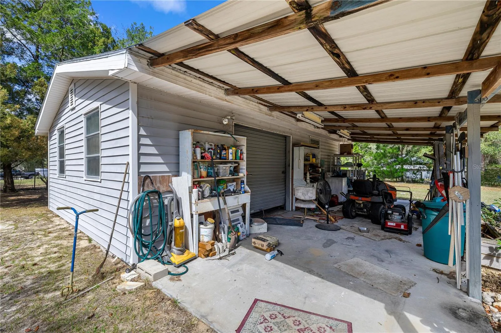 carport with workshop kitchen half bath and laundryk