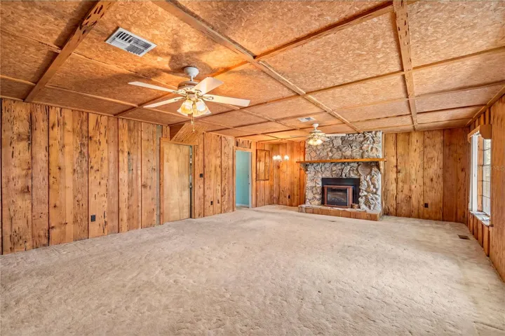 family room with wood burning fireplace, door to mudroom/study and primary bedroom virtual staged