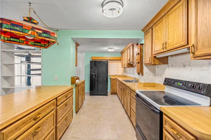 wood cabinets, galley kitchen with snackbar virtual staged