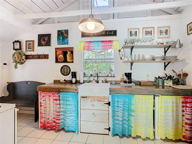 The kitchen is eclectic and adds flare to the home.  Dishes are easily accessible on the open shelving.