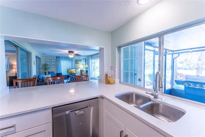 The newly remodeled kitchen the heart of the home, showcasing shaker cabinetry, Corian countertops, and an extended layout that opens seamlessly into the family room-perfect for entertaining.