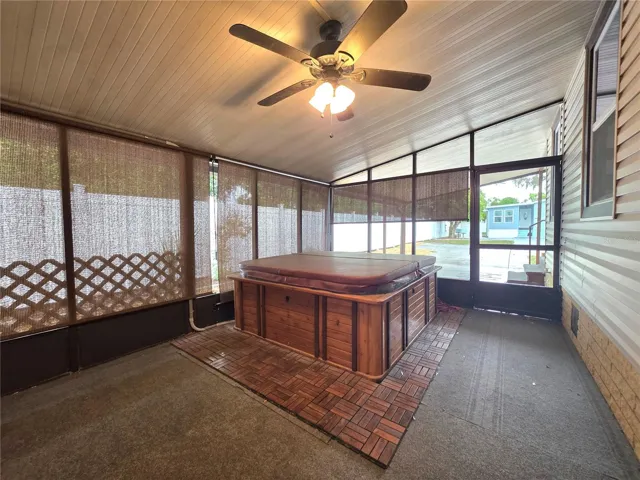 Large screen porch with ceiling fans, roll-down sunshades, hot tub &amp; attached utility/golf cart garage.