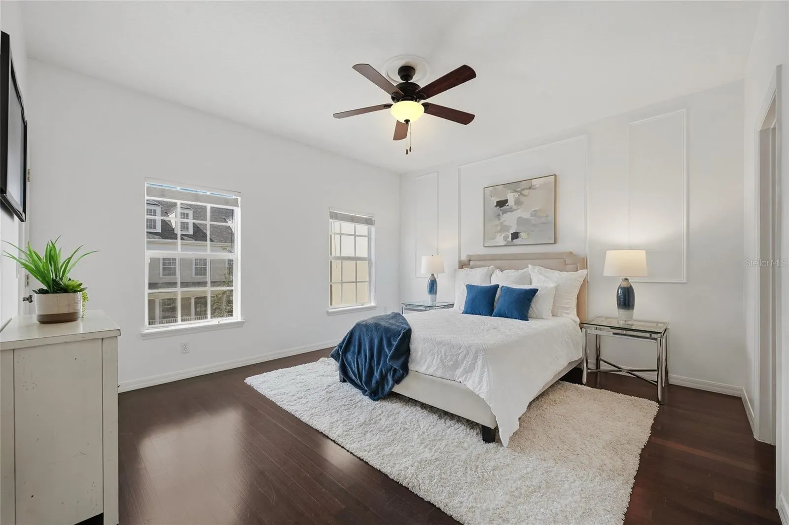 Primary Bedroom Spacious primary suite with hardwood flooring, abundant natural light and elegant feature-wall detailing.