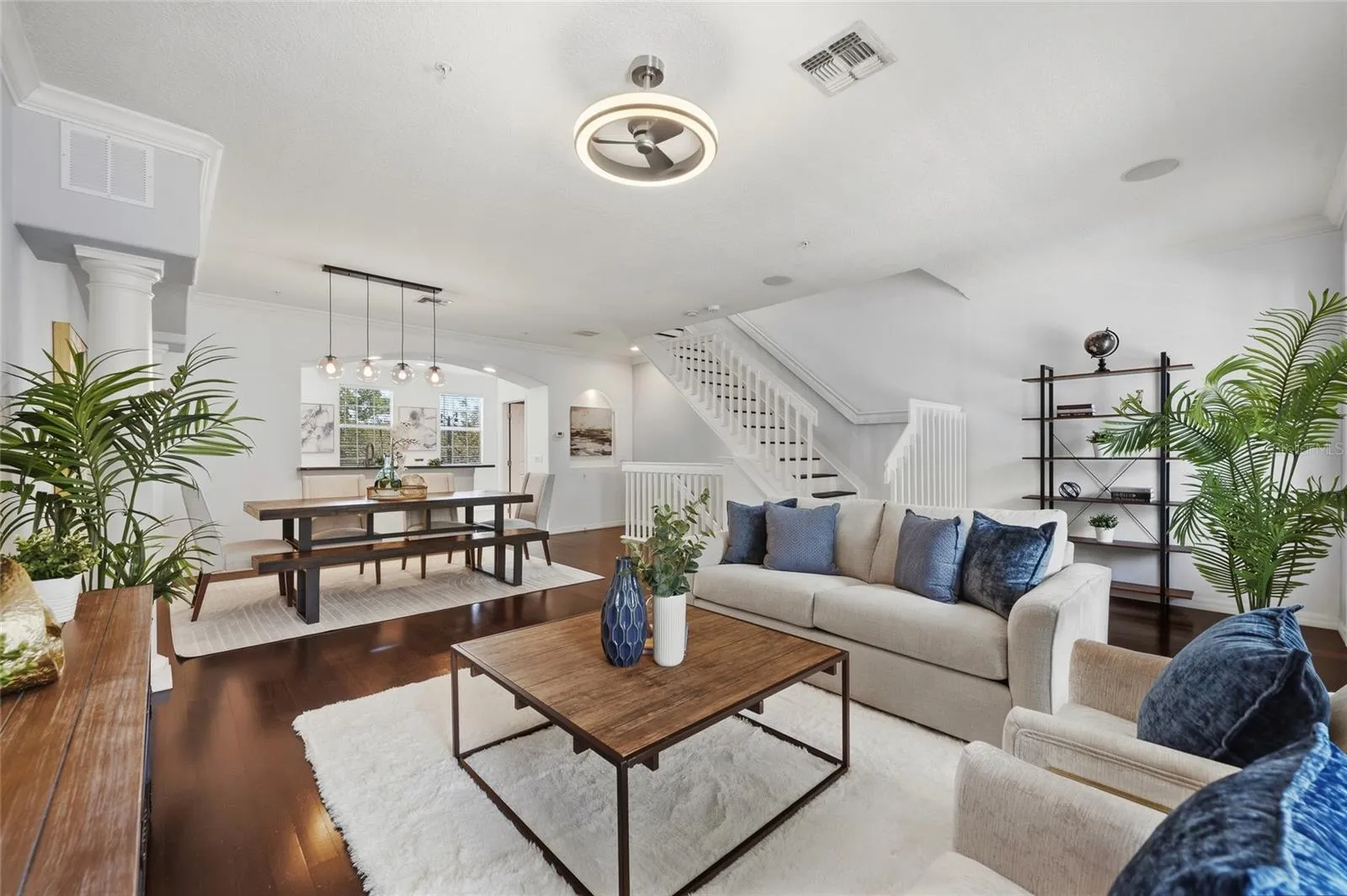 Expansive living and dining area showcasing the flexible floor plan and staircase to the upper level.