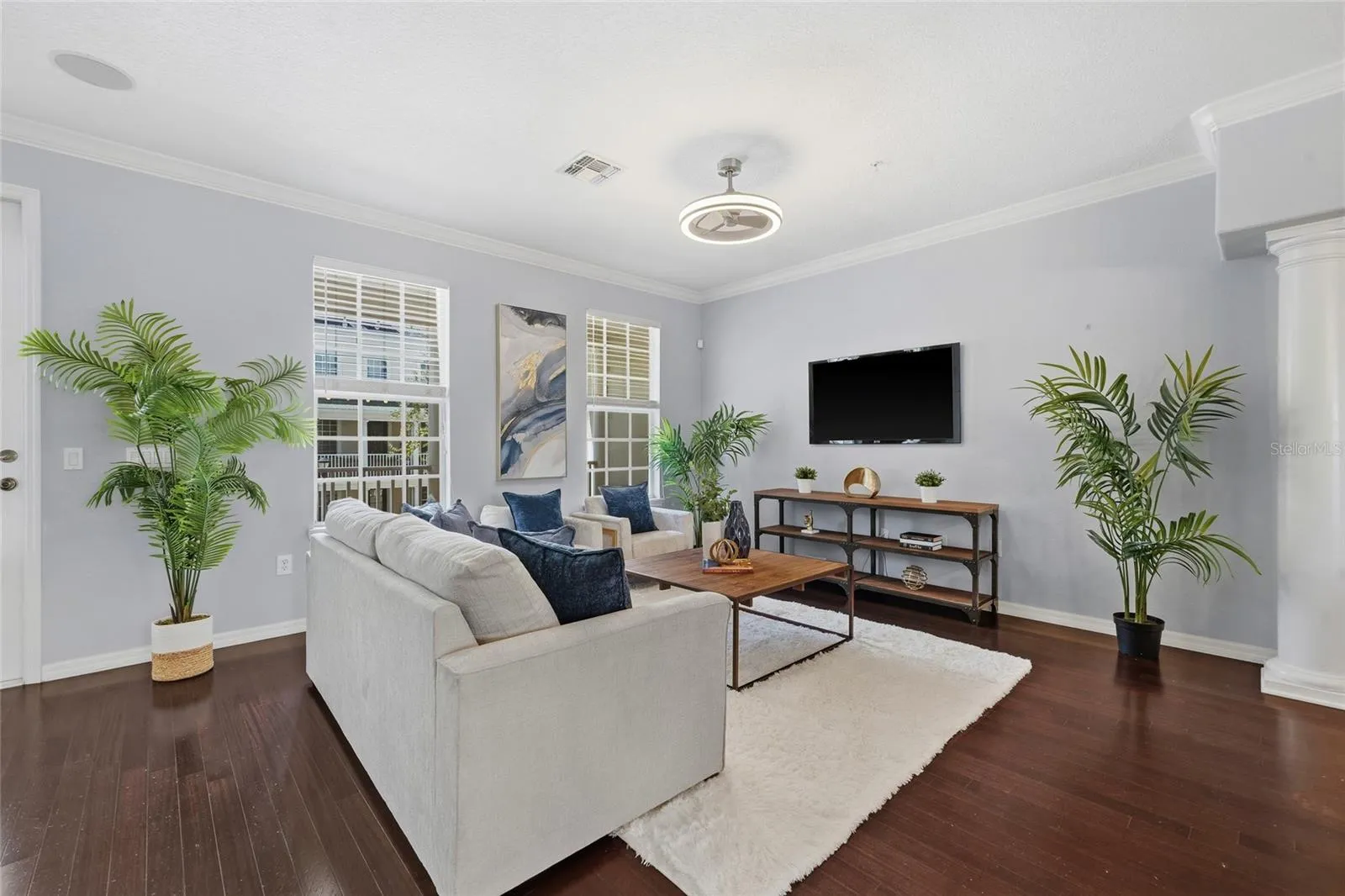 Bright, spacious living room with hardwood flooring, large windows and plenty of room for multiple seating arrangements.