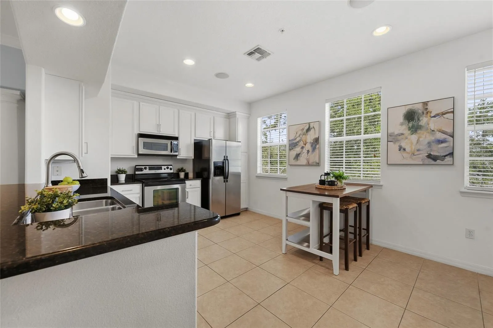 White cabinetry, granite countertops, stainless steel appliances and generous workspace.