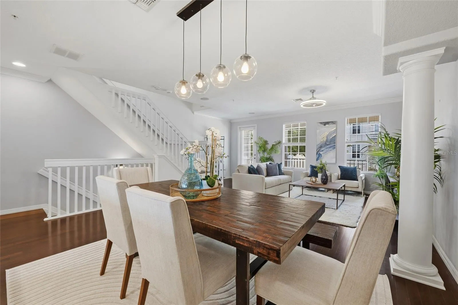 Open-concept living and dining spaces with hardwood floors, crown molding and excellent natural light.